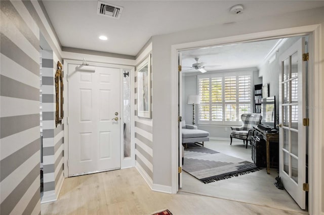 entryway with ceiling fan and light hardwood / wood-style flooring