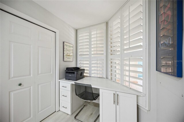 home office featuring built in desk and light hardwood / wood-style flooring