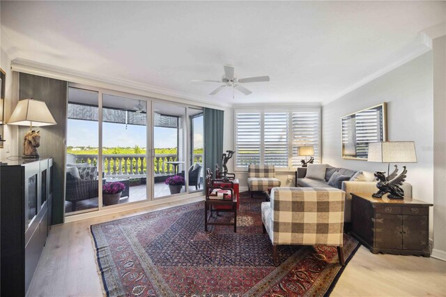 living room featuring ceiling fan, light wood-type flooring, and ornamental molding