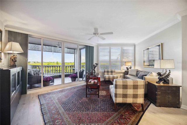 living room featuring ceiling fan, ornamental molding, light hardwood / wood-style floors, and a wealth of natural light