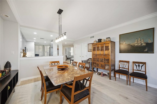 dining space featuring light hardwood / wood-style floors and crown molding