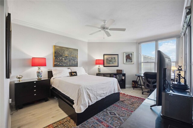 bedroom featuring ceiling fan, light wood-type flooring, and crown molding