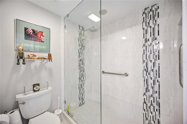 bathroom featuring tiled shower and toilet