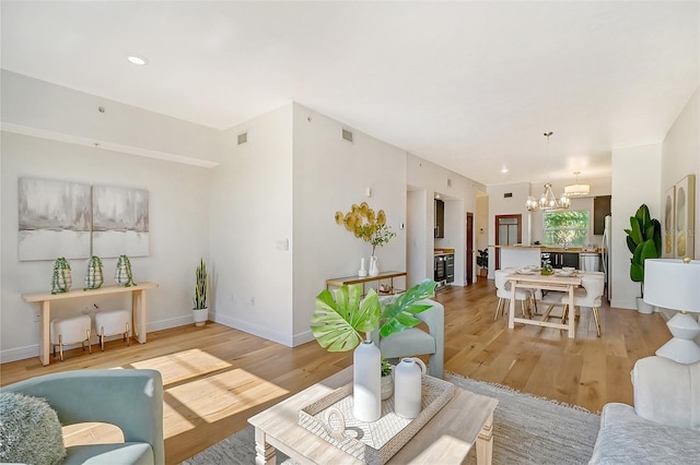 living room featuring a notable chandelier and light wood-type flooring