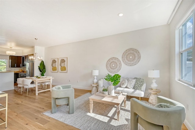 living room with a notable chandelier and light wood-type flooring