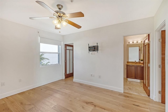 empty room with ceiling fan and light hardwood / wood-style floors