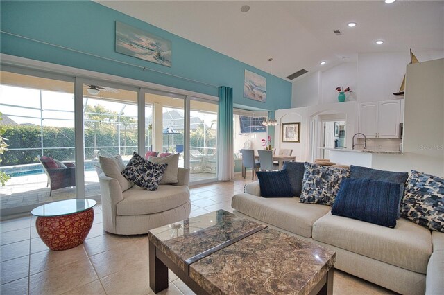 tiled living room featuring sink and high vaulted ceiling