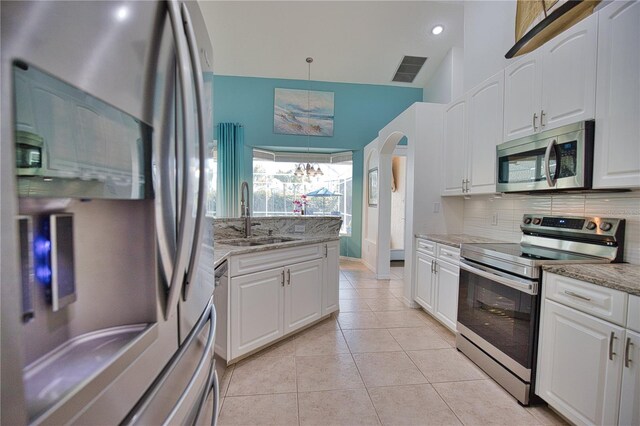 kitchen with white cabinetry, sink, stainless steel appliances, and light stone counters