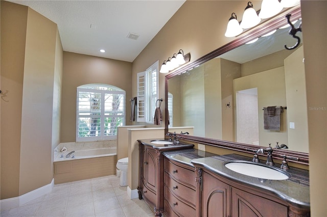 bathroom featuring tile patterned flooring, a bathtub, toilet, and dual bowl vanity