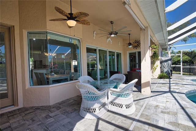 view of patio / terrace featuring ceiling fan and glass enclosure