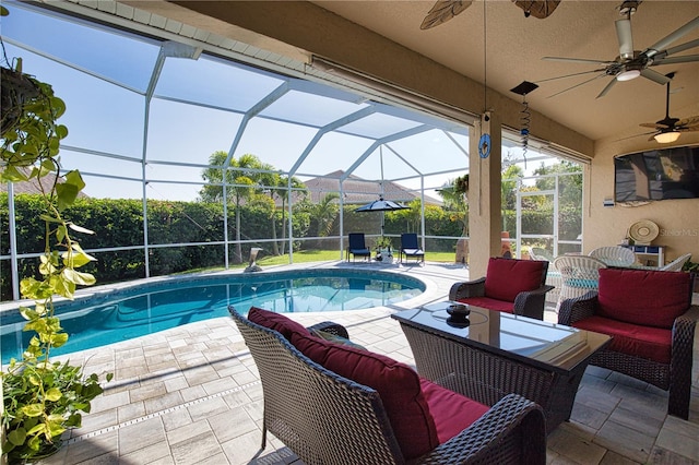 view of pool featuring ceiling fan, glass enclosure, outdoor lounge area, and a patio