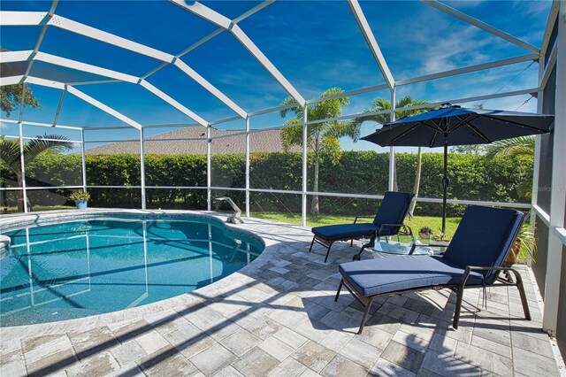 view of swimming pool featuring a patio area and a lanai