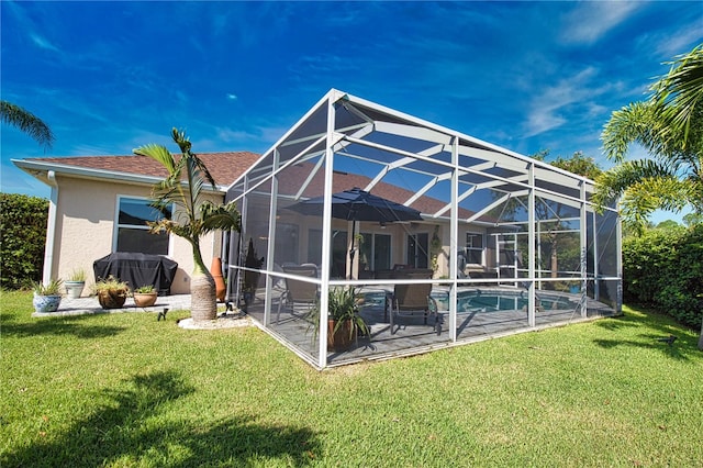 back of property featuring glass enclosure and a lawn