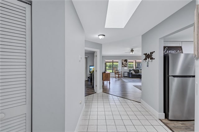 hallway with a skylight and light hardwood / wood-style floors