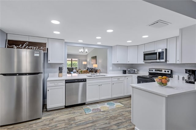 kitchen with sink, white cabinetry, appliances with stainless steel finishes, and light hardwood / wood-style floors