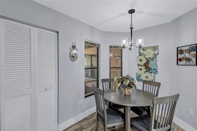 dining area with a notable chandelier and dark hardwood / wood-style flooring