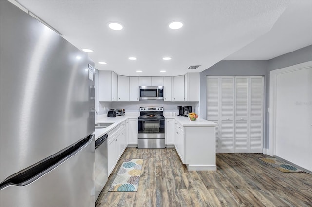 kitchen with sink, white cabinets, hardwood / wood-style floors, and stainless steel appliances