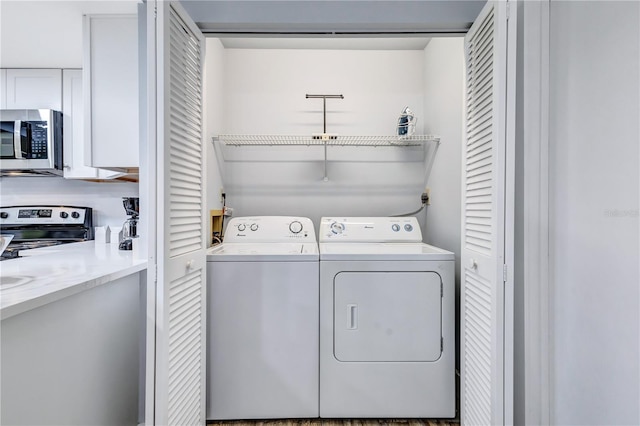 laundry room featuring hardwood / wood-style flooring and washer and dryer