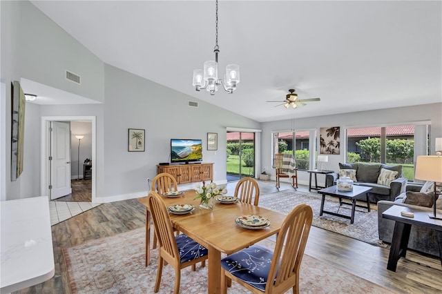 dining room featuring high vaulted ceiling, light hardwood / wood-style flooring, and ceiling fan with notable chandelier