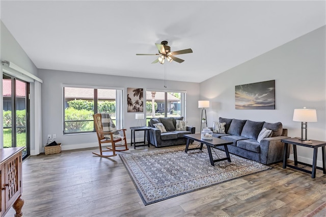 living room with ceiling fan, vaulted ceiling, and hardwood / wood-style floors