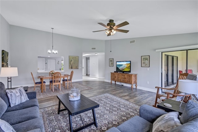 living room featuring hardwood / wood-style floors, ceiling fan with notable chandelier, and high vaulted ceiling