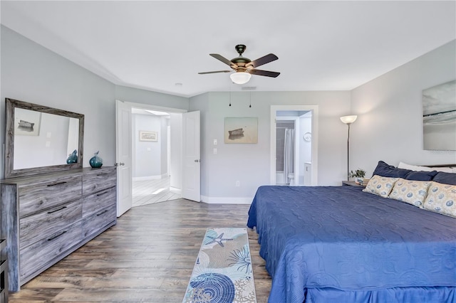 bedroom featuring hardwood / wood-style floors, ceiling fan, and ensuite bath