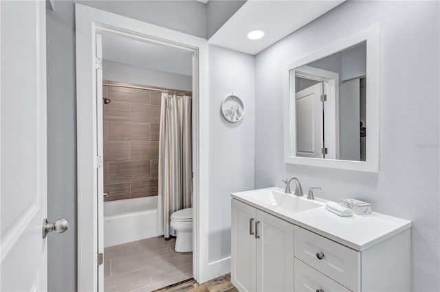 full bathroom featuring tile patterned floors, shower / bath combo with shower curtain, vanity, and toilet