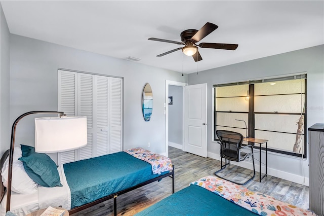 bedroom featuring ceiling fan, a closet, and hardwood / wood-style floors