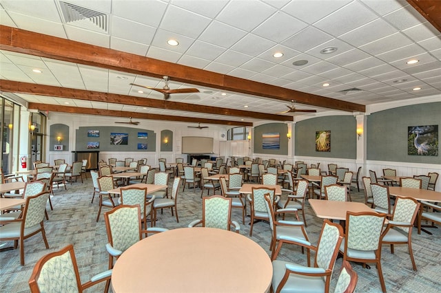 dining room featuring ceiling fan, beamed ceiling, and carpet