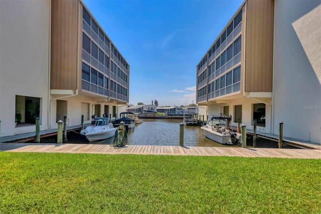 view of dock featuring a lawn and a water view