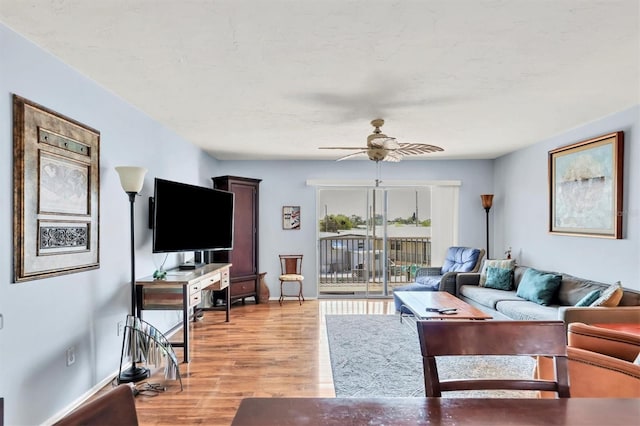 living room featuring light hardwood / wood-style flooring and ceiling fan