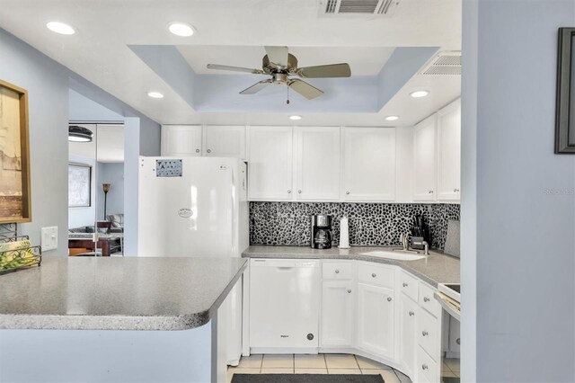 kitchen with white cabinetry, a raised ceiling, light tile patterned flooring, and white appliances