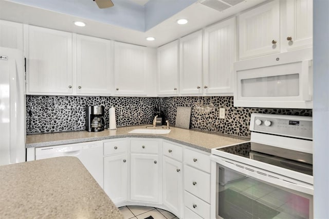 kitchen with decorative backsplash, white cabinetry, sink, light tile patterned floors, and white appliances