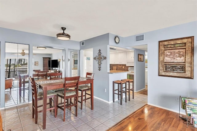 dining room with light tile patterned floors, visible vents, baseboards, and ceiling fan