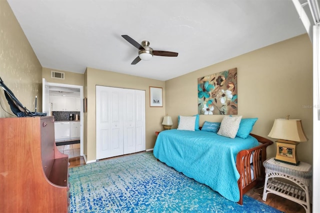 tiled bedroom with ceiling fan and a closet