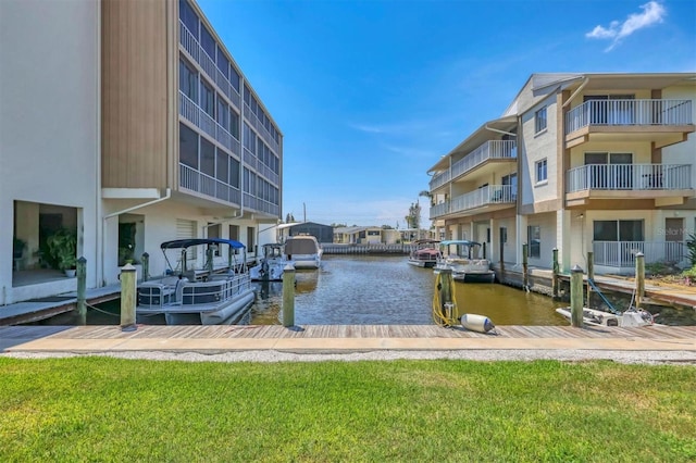 view of dock with a water view and a yard