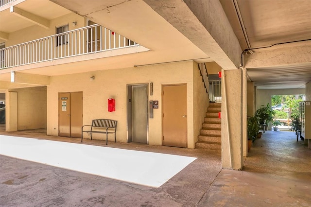 exterior space with elevator and stucco siding