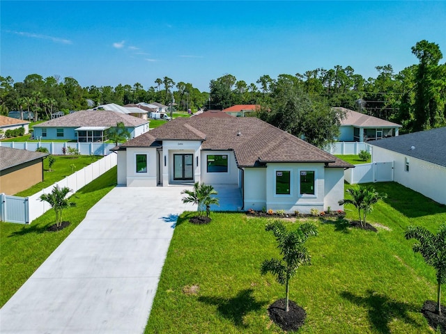 mediterranean / spanish-style house featuring driveway, a front lawn, fence private yard, and stucco siding