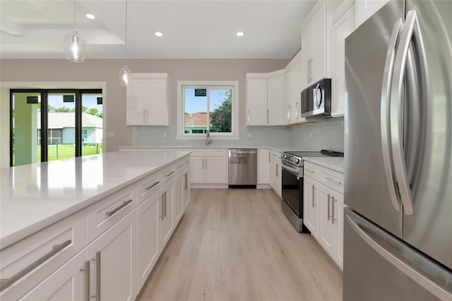 kitchen featuring plenty of natural light, light hardwood / wood-style flooring, appliances with stainless steel finishes, and tasteful backsplash