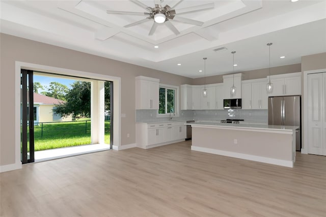 kitchen featuring a healthy amount of sunlight, appliances with stainless steel finishes, white cabinetry, and light hardwood / wood-style floors