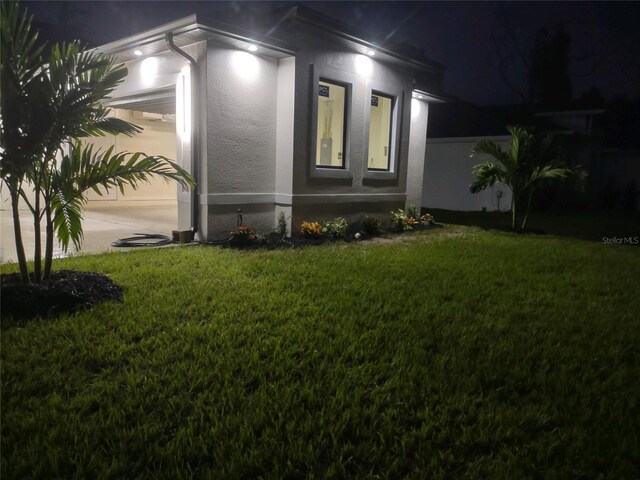 property exterior at twilight featuring a lawn