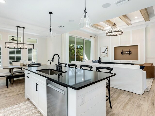 kitchen with pendant lighting, dishwasher, white cabinets, sink, and beam ceiling