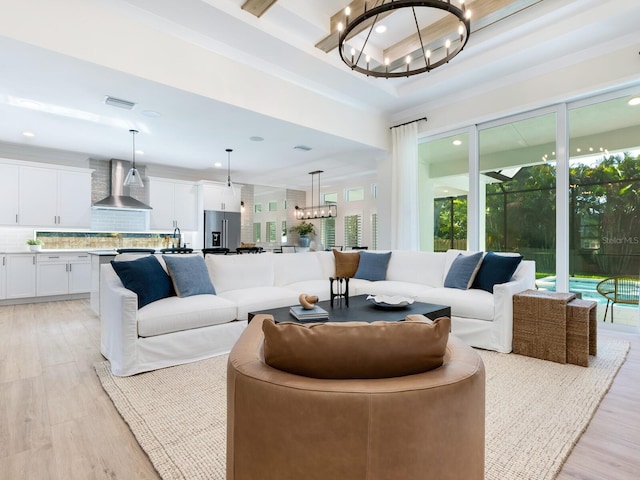 living room with a chandelier, a high ceiling, and light hardwood / wood-style floors