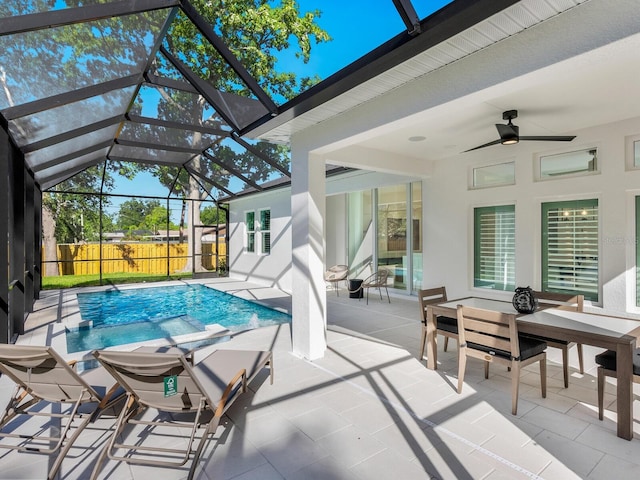 view of pool with a patio, glass enclosure, and ceiling fan