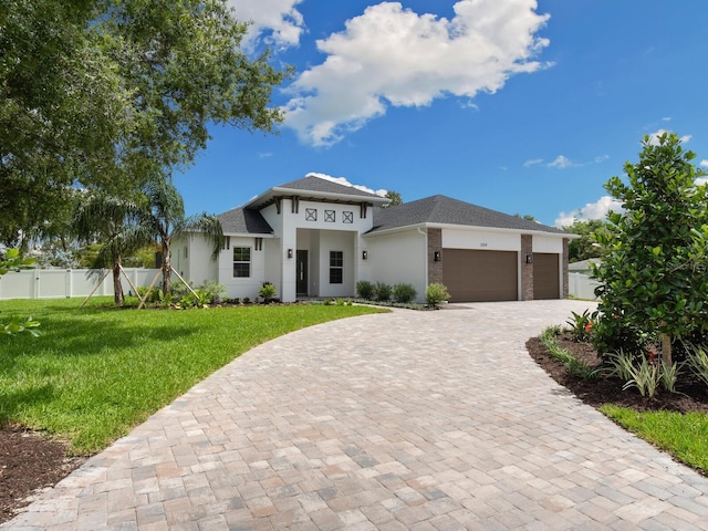 view of front of property featuring a front yard and a garage