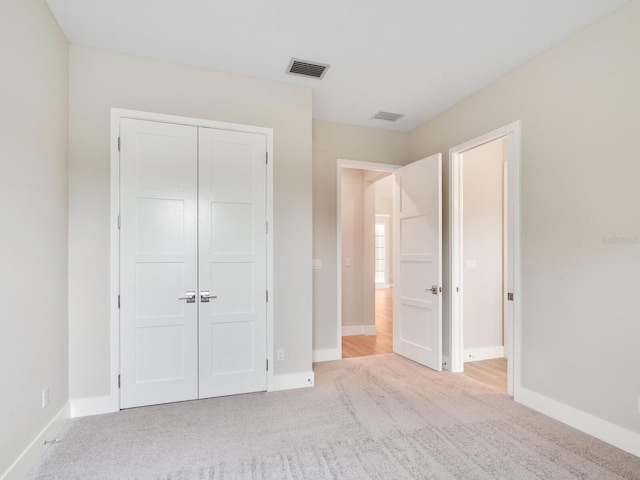 unfurnished bedroom featuring a closet and light carpet