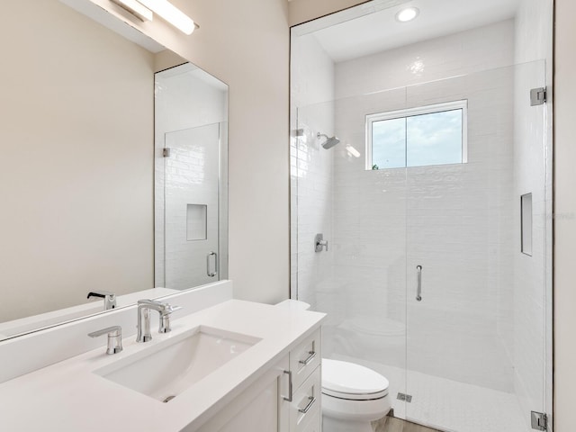 bathroom with toilet, vanity, and walk in shower