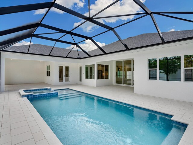 view of swimming pool with an in ground hot tub, a lanai, french doors, and a patio