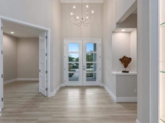 foyer entrance with a chandelier and french doors