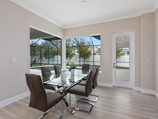 dining room with ornamental molding and light wood-type flooring